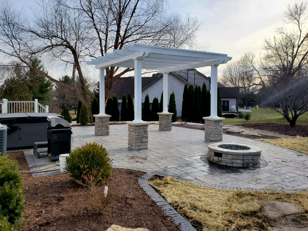 Freestanding pergola on hardscape designed patio with stone columns