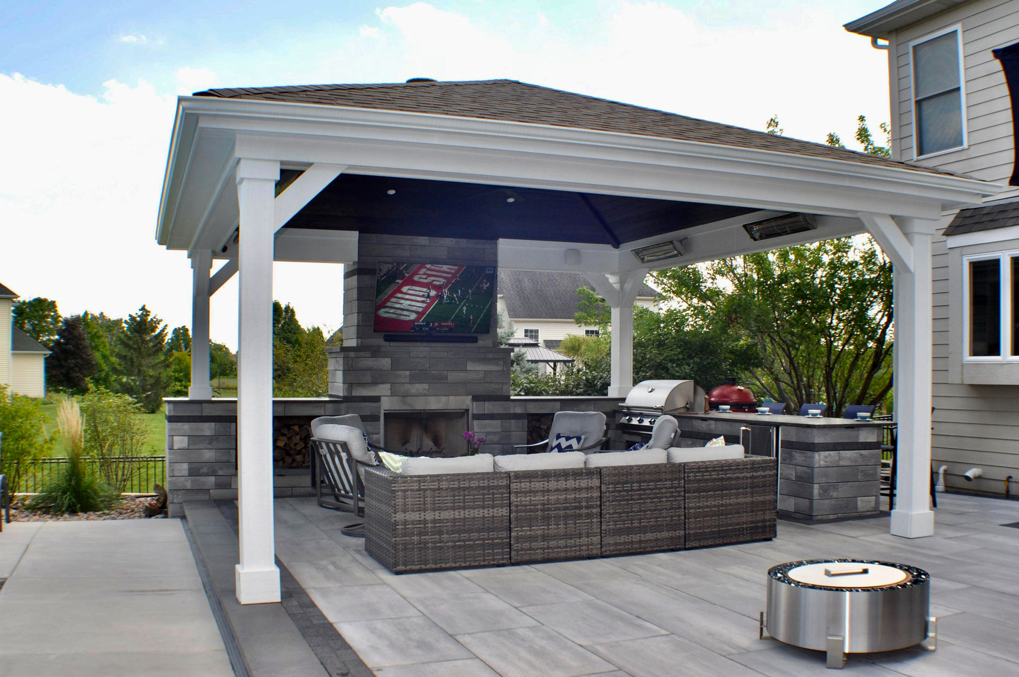 Patio with large gable roof structure over outdoor living room area.