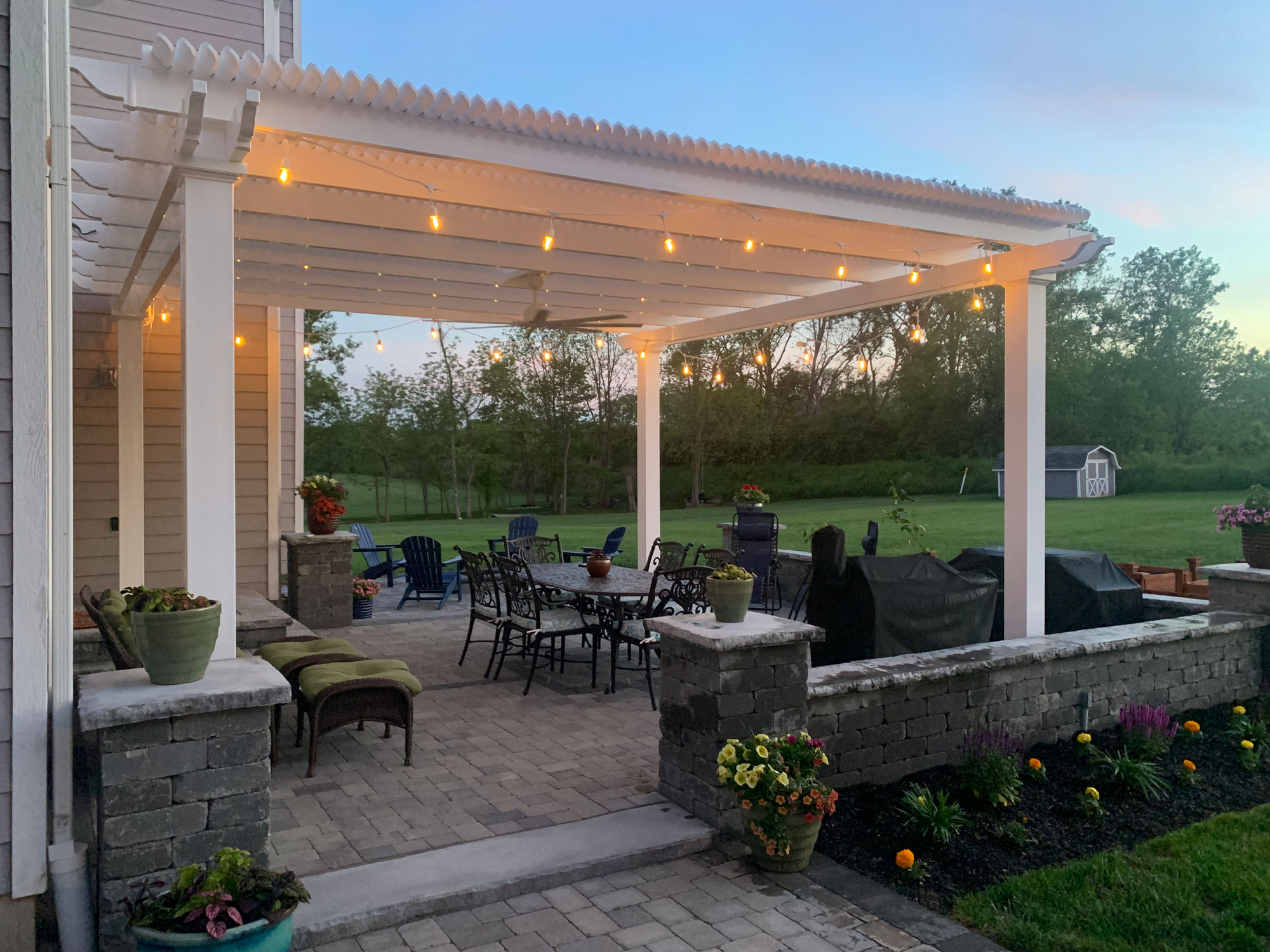 White freestanding pergola over a hardscaped patio outdoor dining room