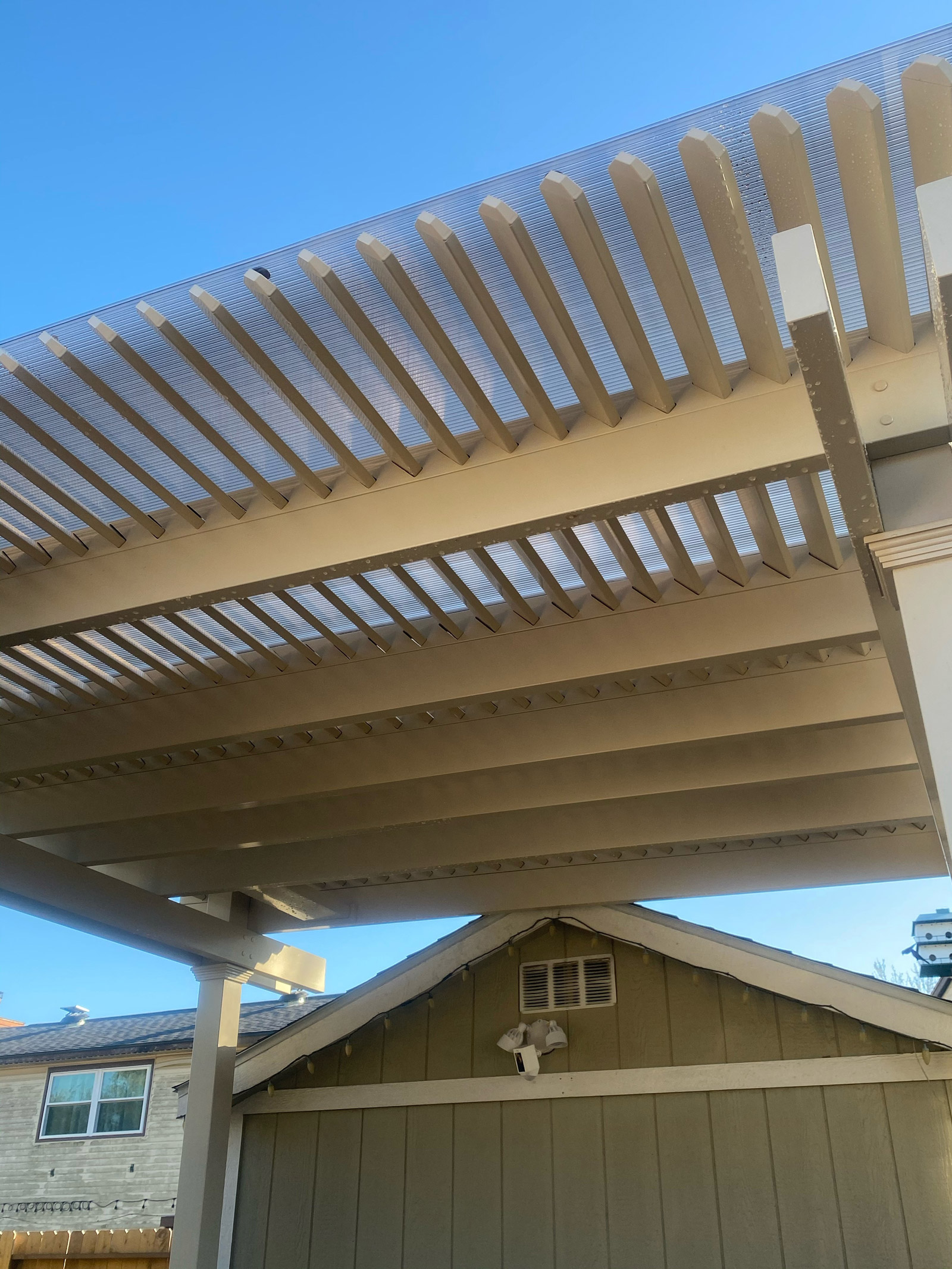 A poloycarbonate panel on top of a pergola to provide coverage from the rain.