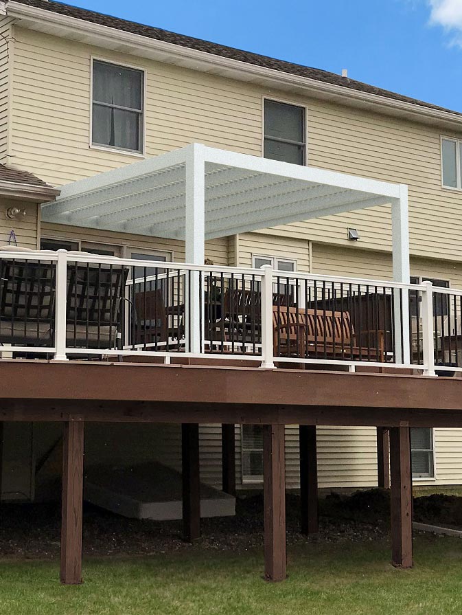 An attached modern pergola on top of a raised deck.