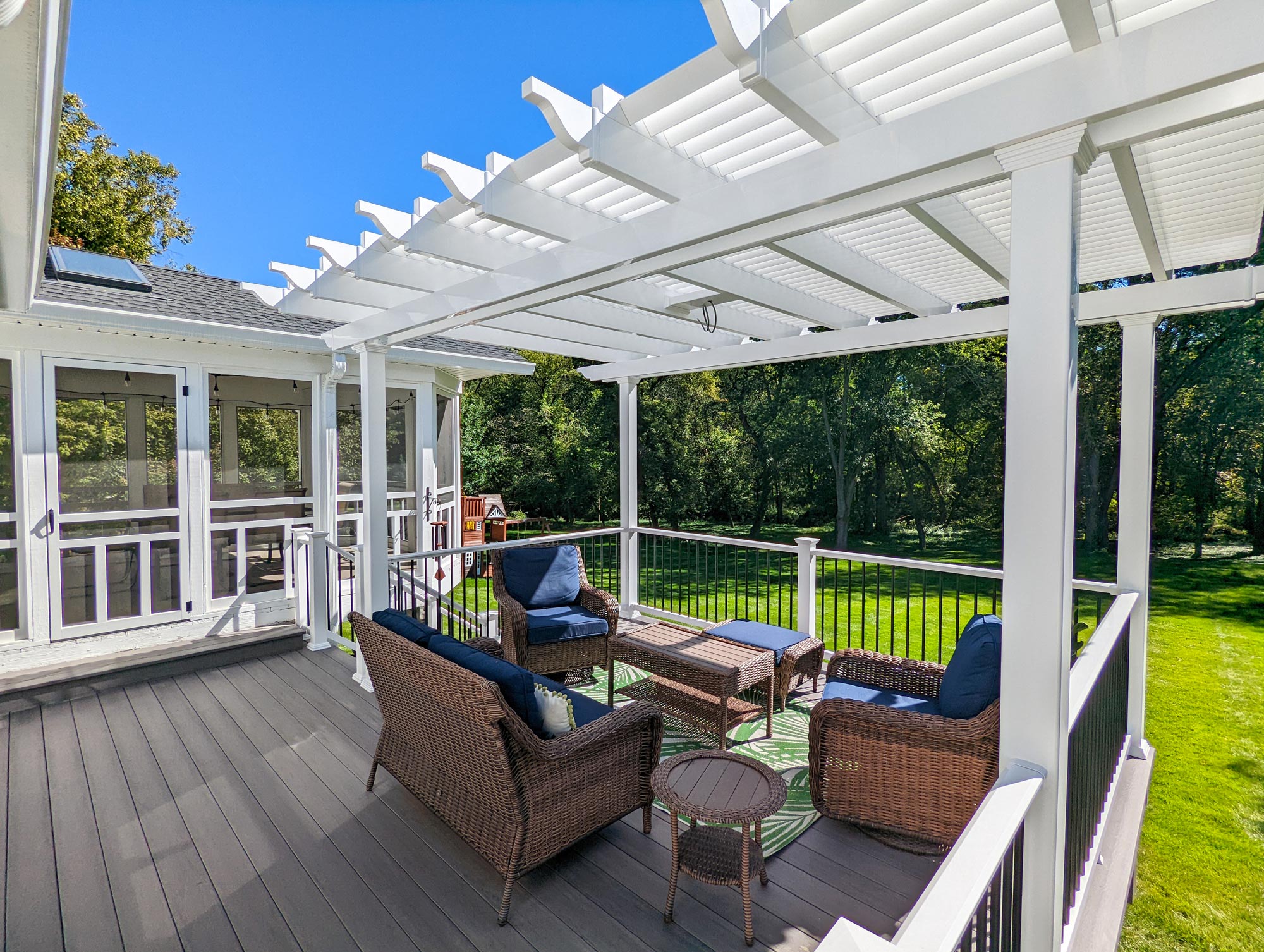 white pergola on a deck with outdoor furniture below