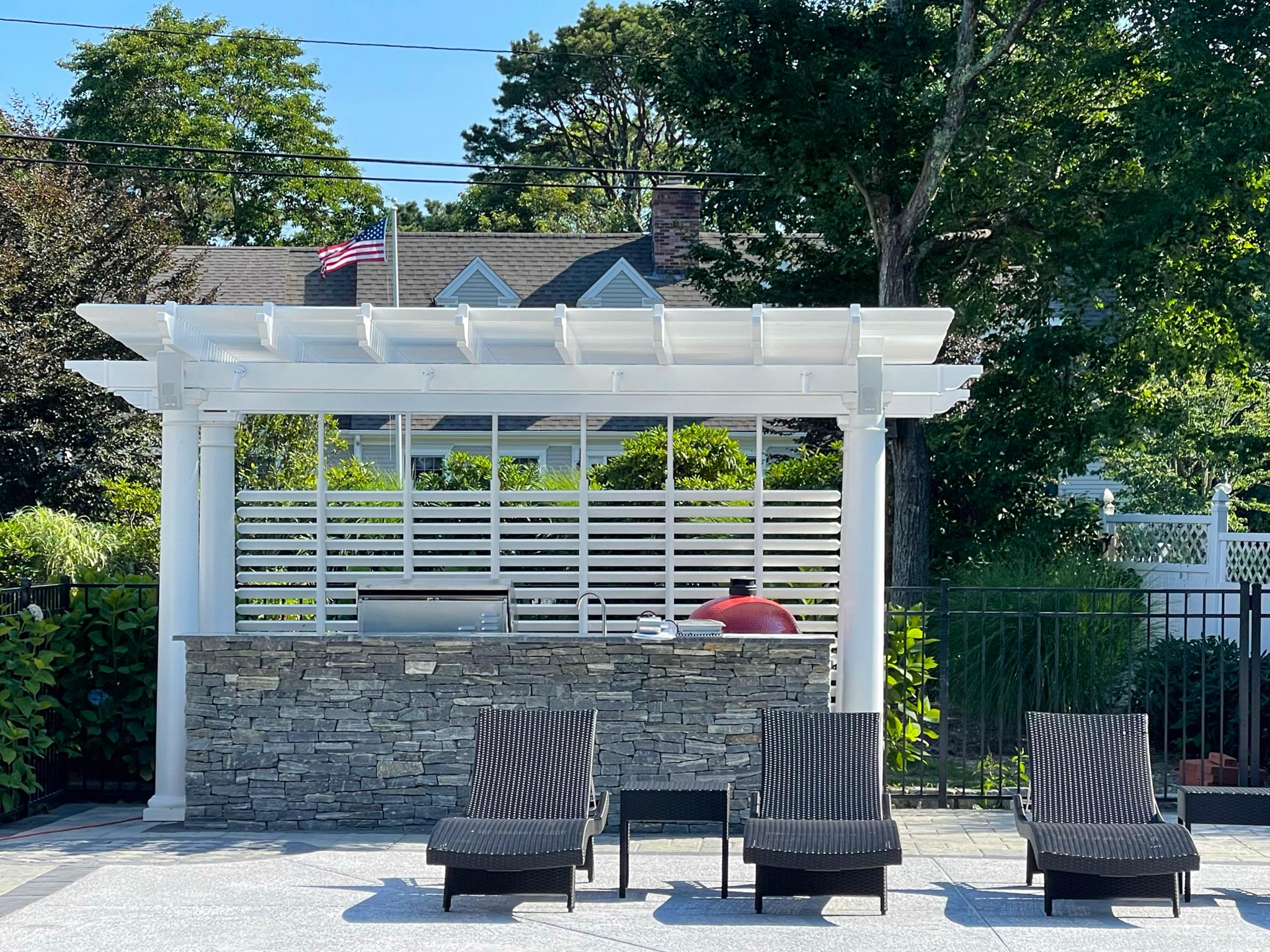 outdoor poolside stone bar with a white pergola attached