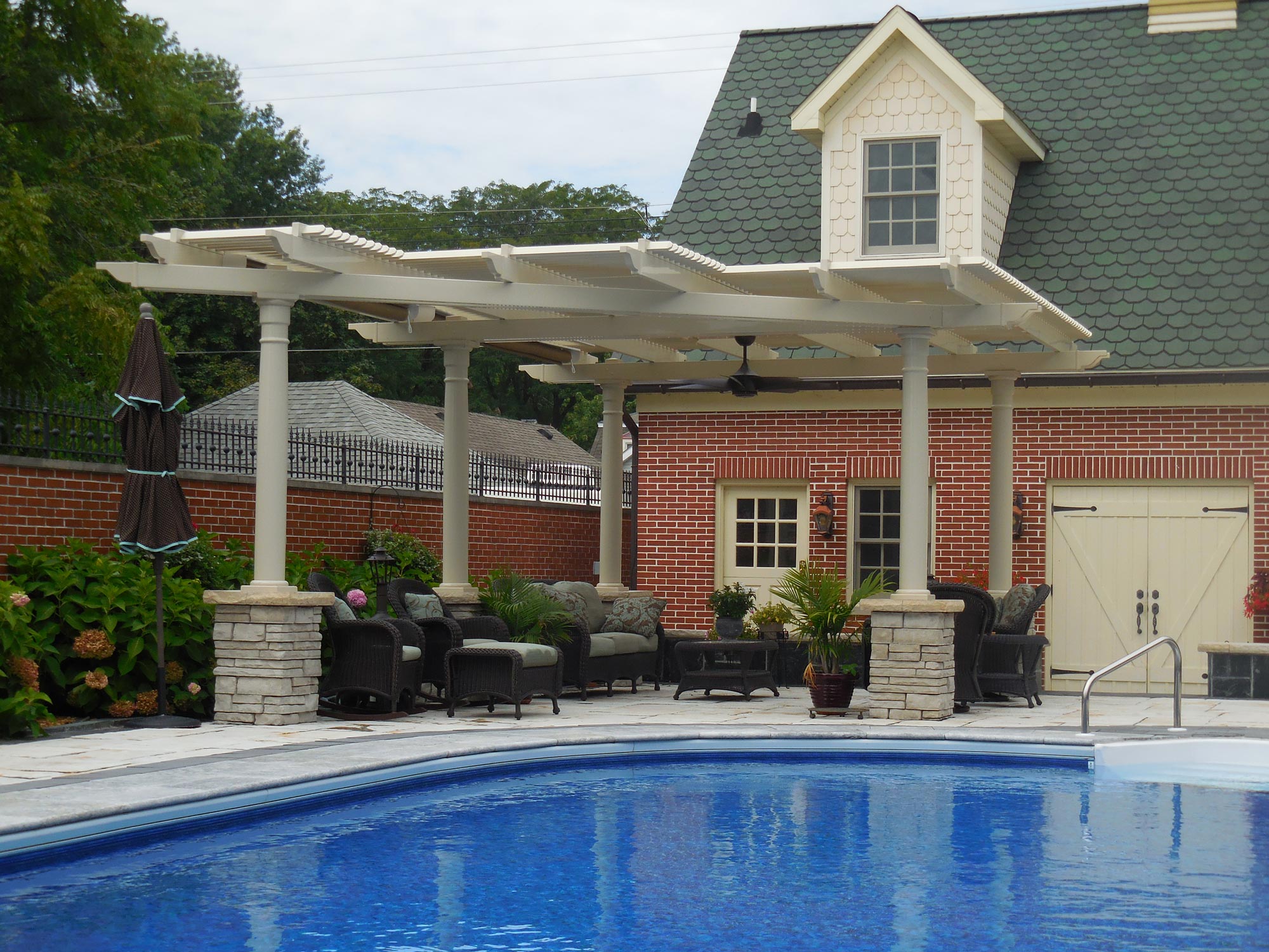 custom pergola next to a pool with outdoor seating