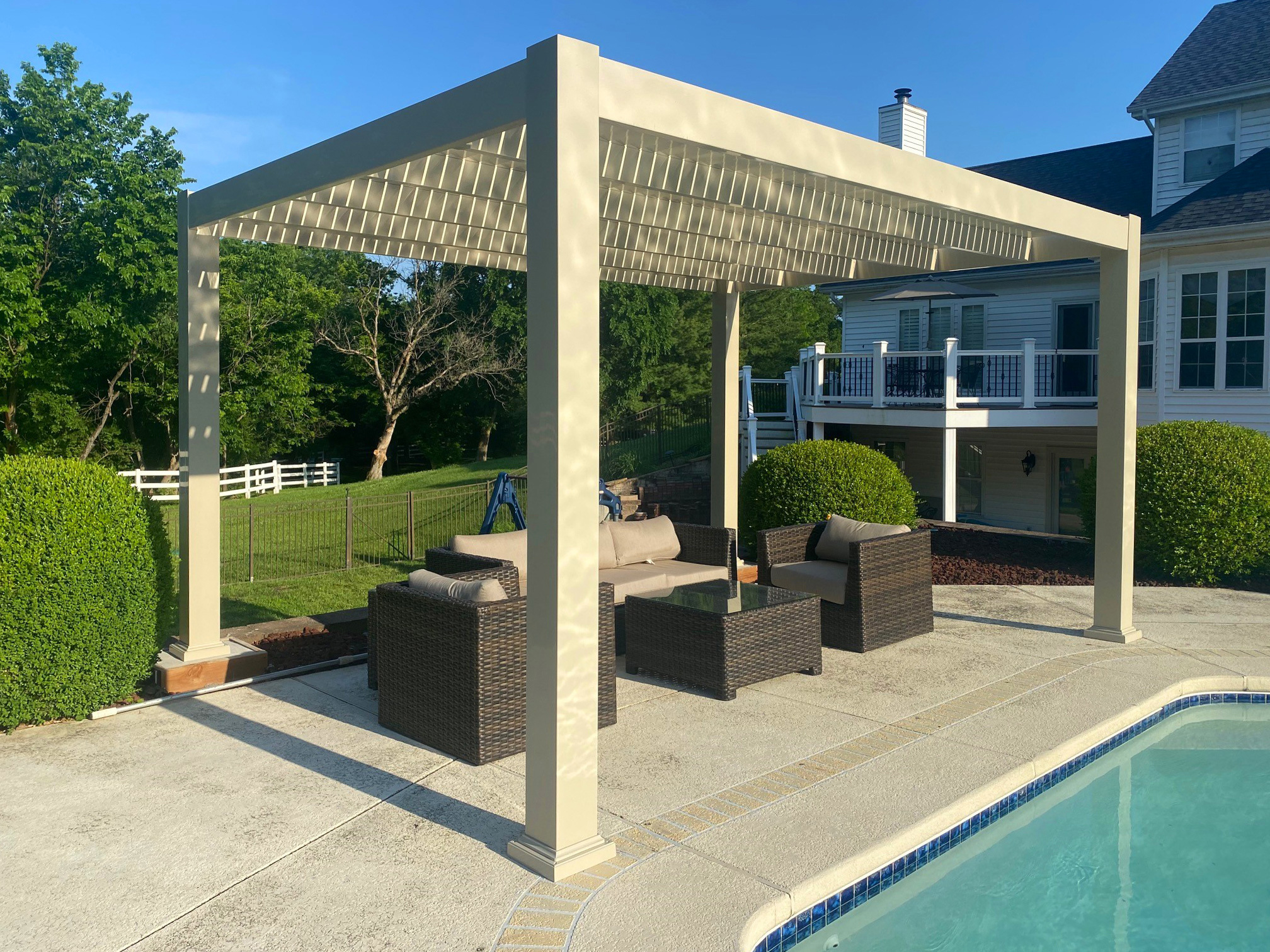 Aluminum pergola frame under vinyl exteriror on a pool patio providing shade