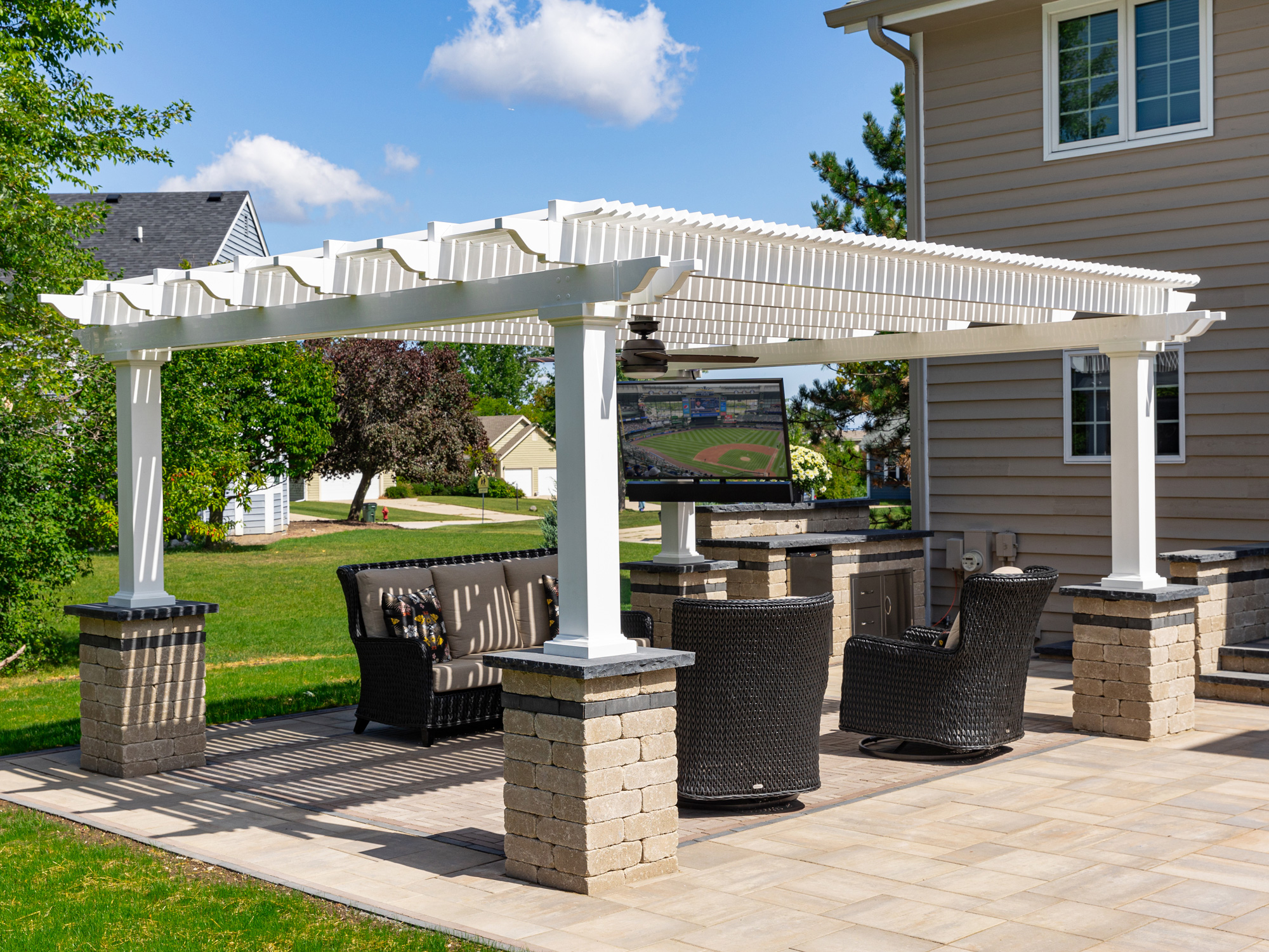 Vinyl pergola sitting on landscape columns over an outdoor sitting area