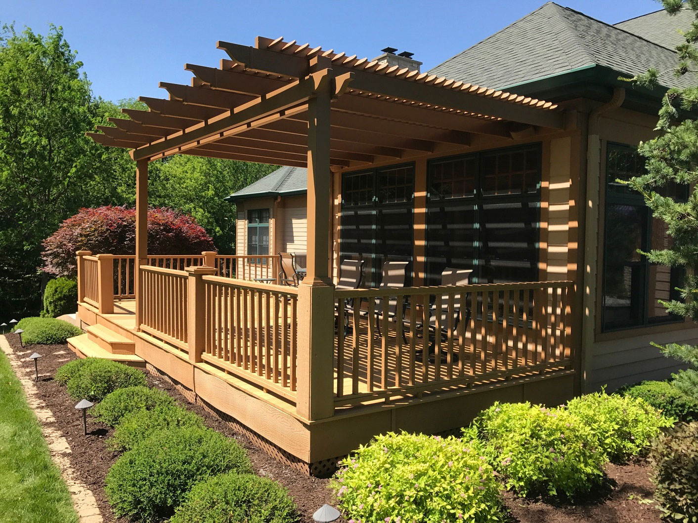 Pergola that has been painted brown on a deck