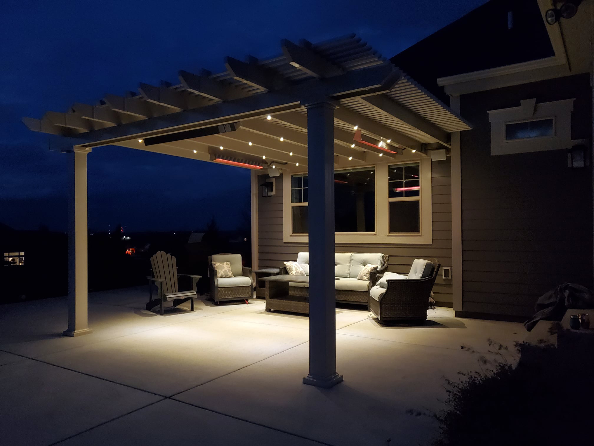 pergola with outdoor heaters attached to the beams of the pergola