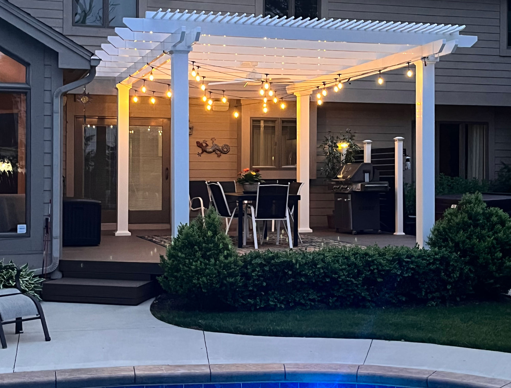 pergola with string lights at dusk near pool