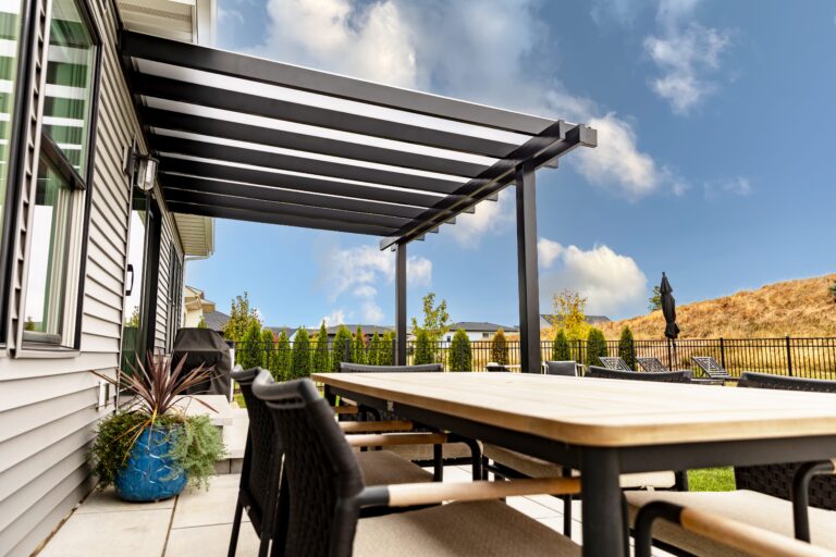Black covered pergola over a patio side view.
