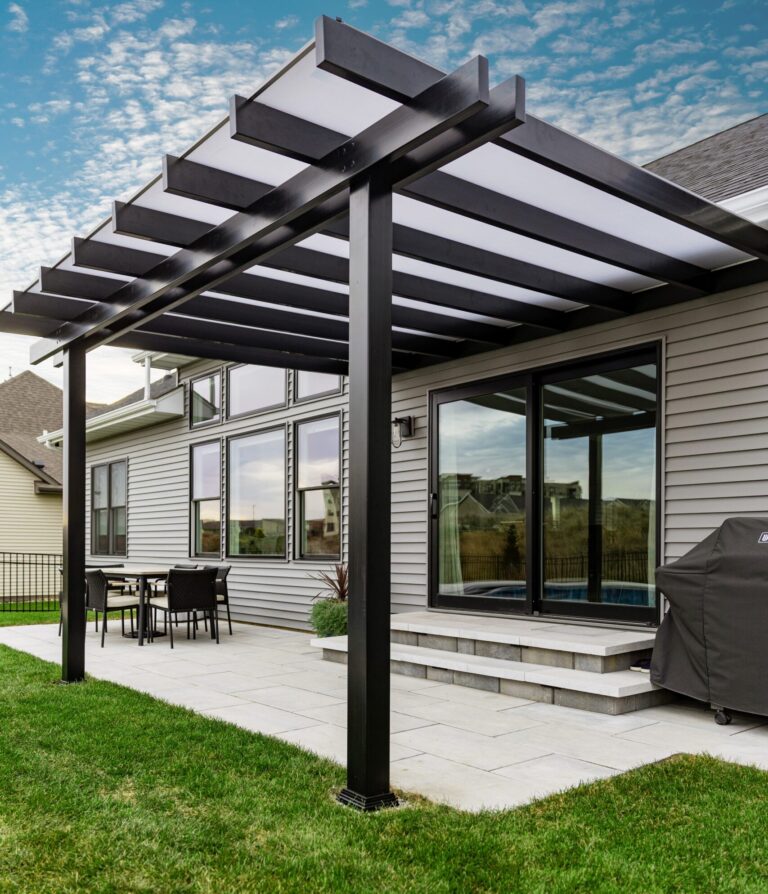 Black covered pergola with white polycarbonate roof over a patio