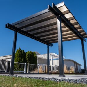 A freestanding patio cover rain proof pergola with bronze polycarbonate roof over patio slab.