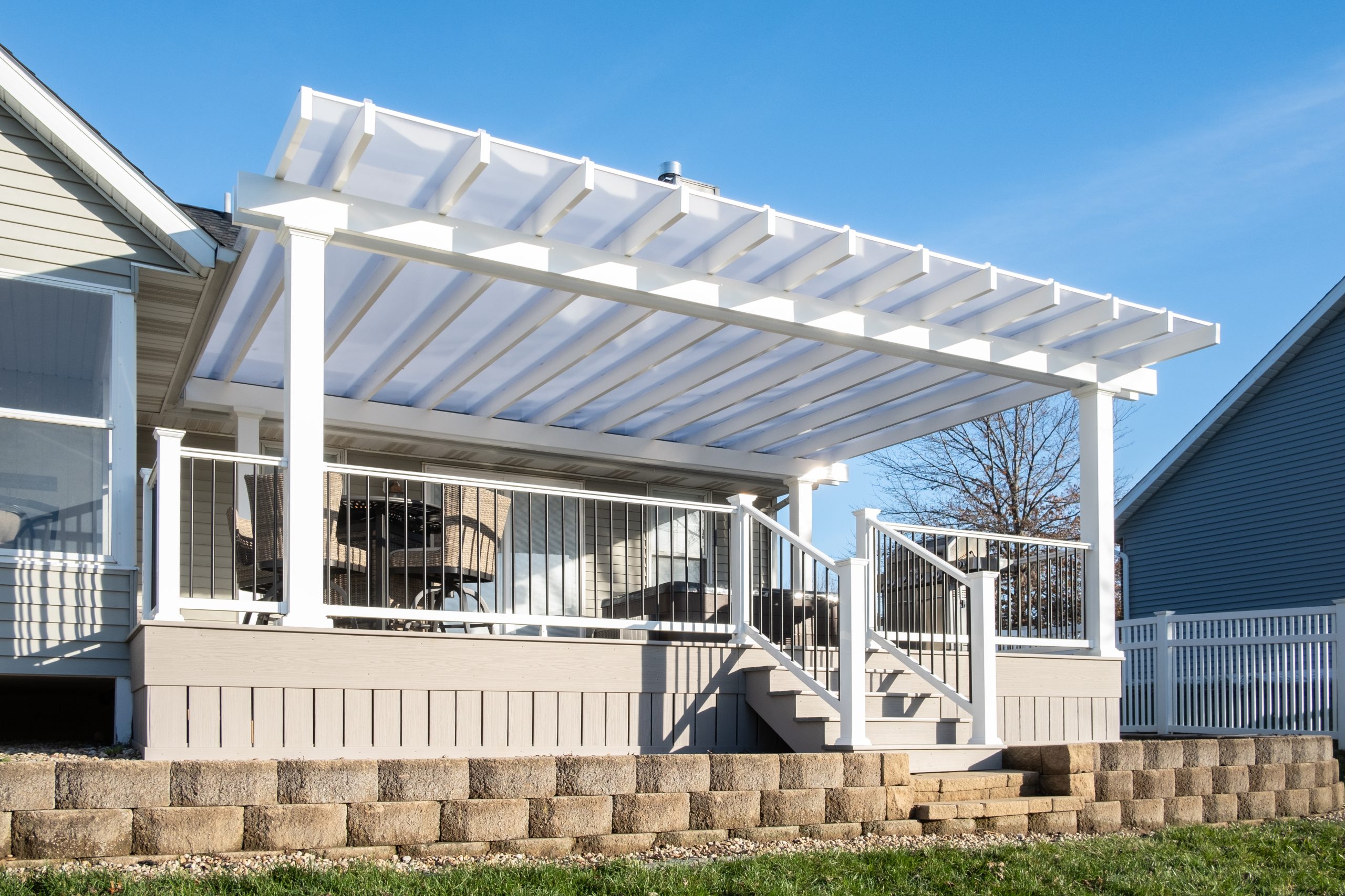 White covered pergola over a large deck