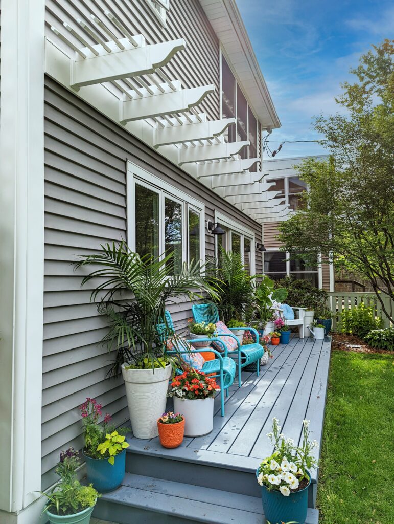 Eyebrow pergolas running the length of a back deck over windows.