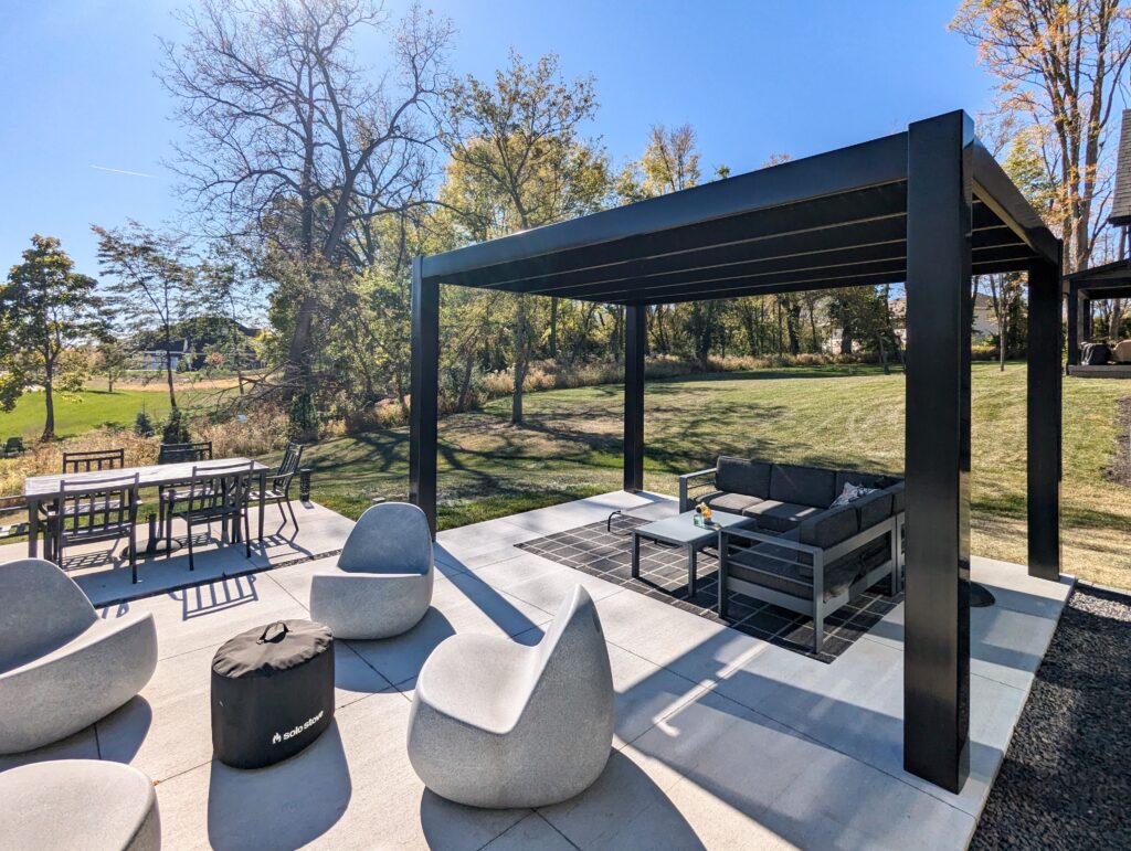 Black modern pergola on a patio with modern furniture