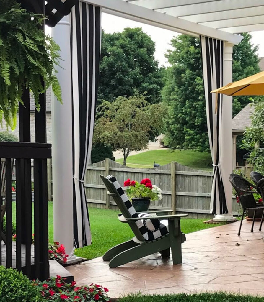 Pergola with long black and white outdoor curtains for privacy