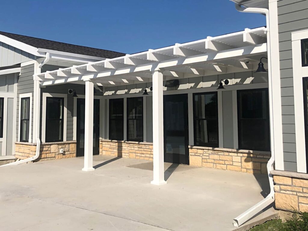 Long shallow pergola attached to a home over a patio
