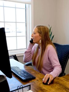 Customer Service agent on the phone with customer while working at a desktop computer