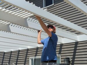 Contractor working on installing the shade purlins of a pergola