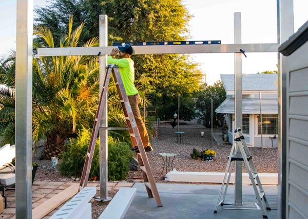 Contractor installing a pergola beam