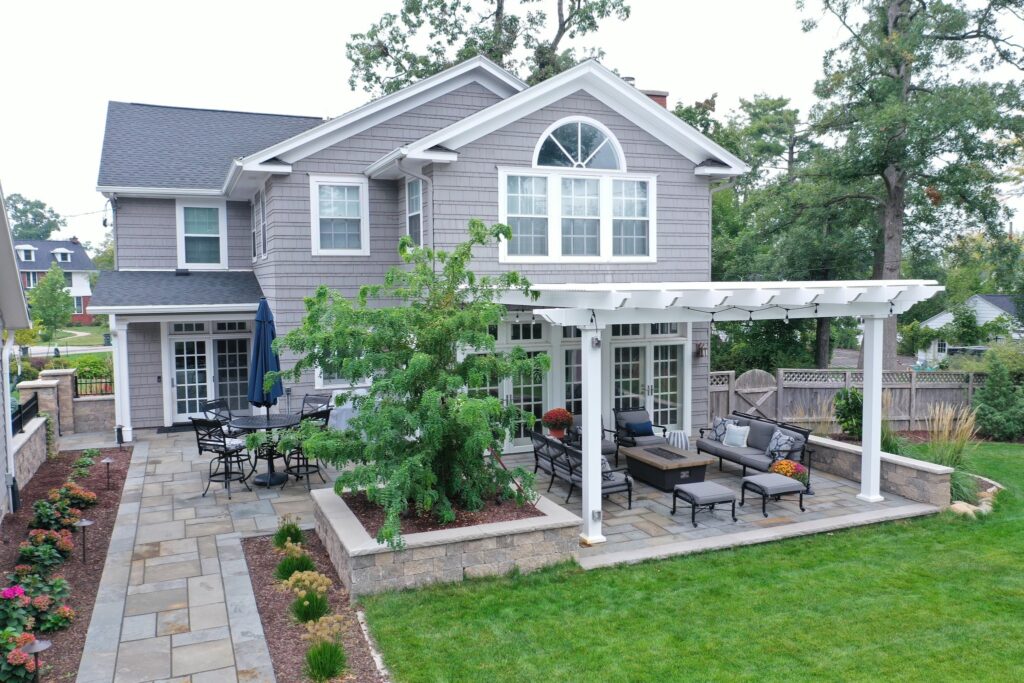 Attached pergola over highly landscaped backyard pavers