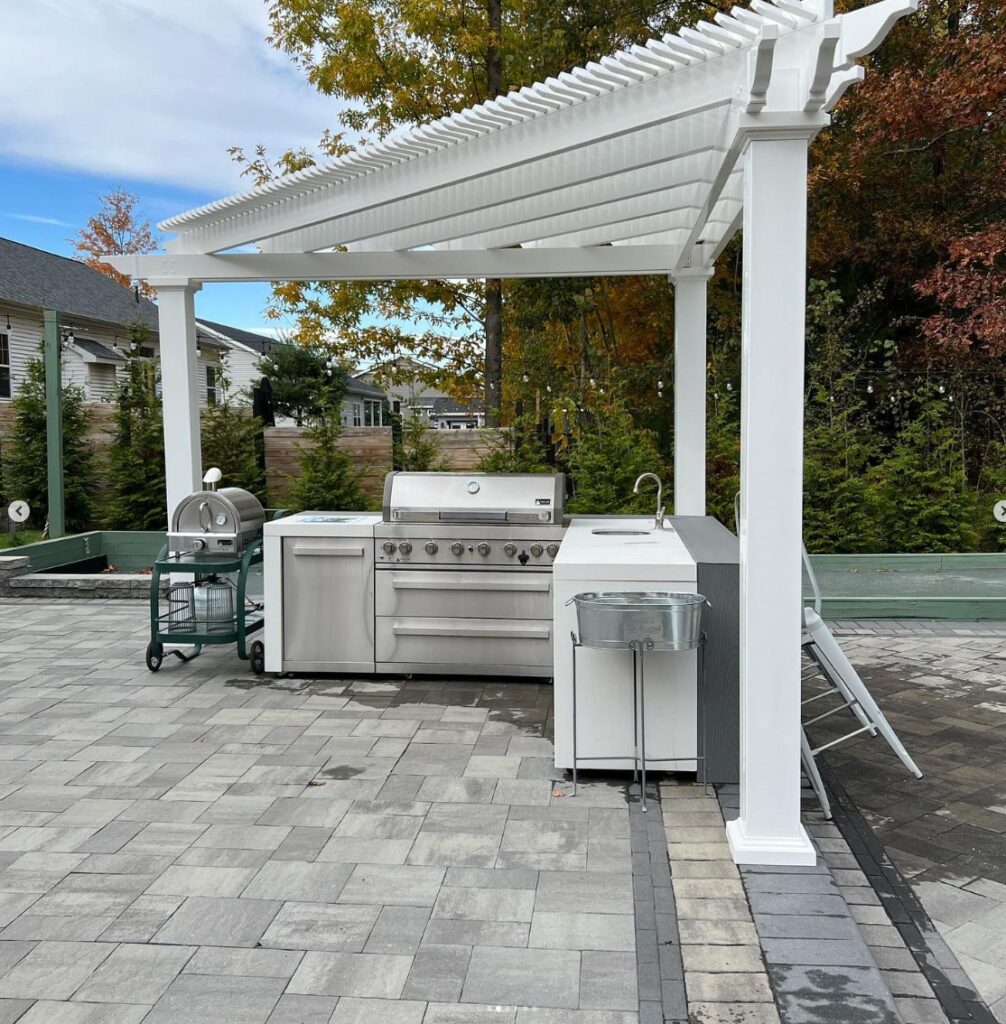 Triangle pergola on a patio over a small outdoor kitchen