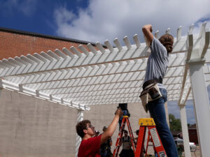 Students work on building a Heartland Pergola for a community park