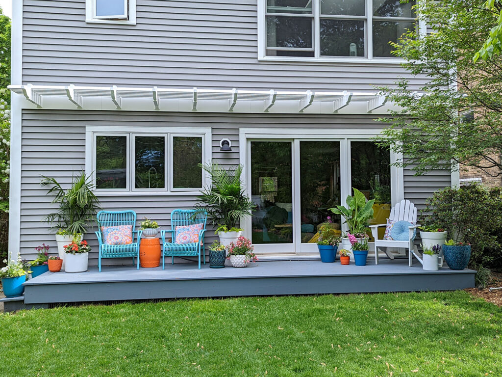 straight on view of an eyebrow pergola stretching across the length of the back of a house