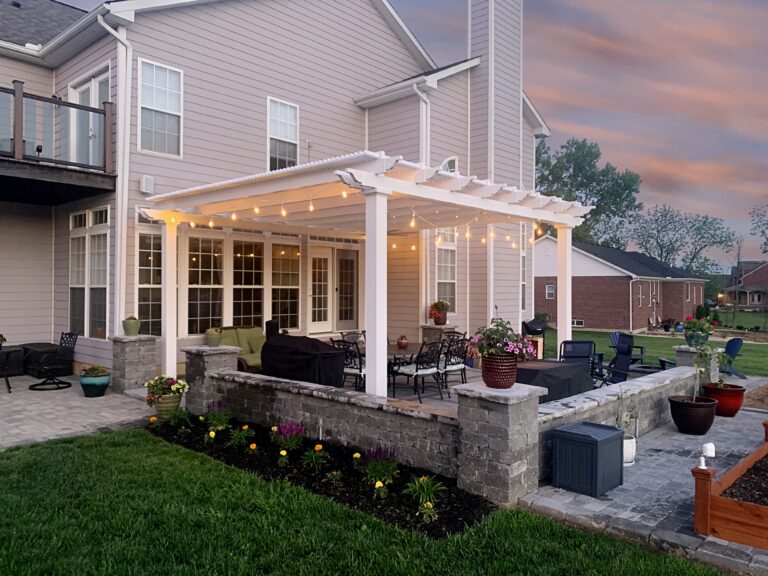 White pergola over patio at dusk with string lights