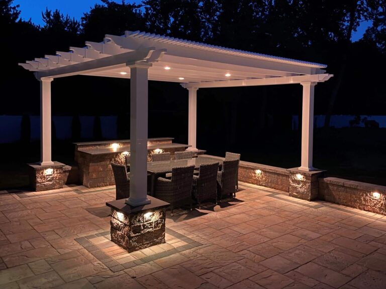 Night view of a pergola light up over a paver patio