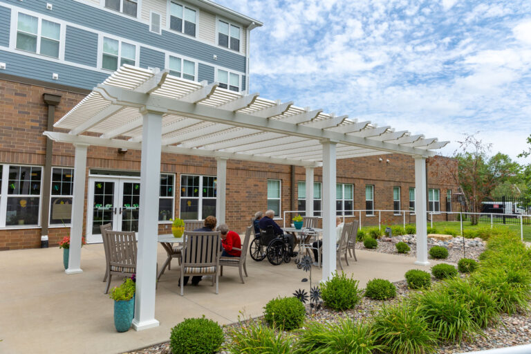 large shade pergola over outdoor courtyard area of a senior living facility