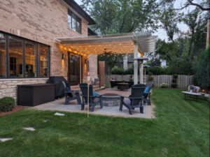 Attached patio pergola at dusk with lights and outdoor fan