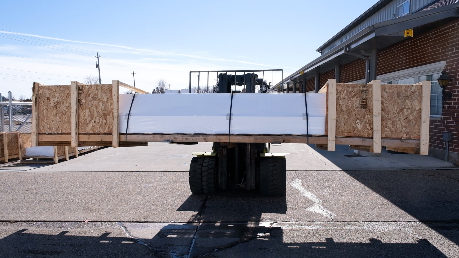 Fork truck carrying a pergola packaged up for shipping
