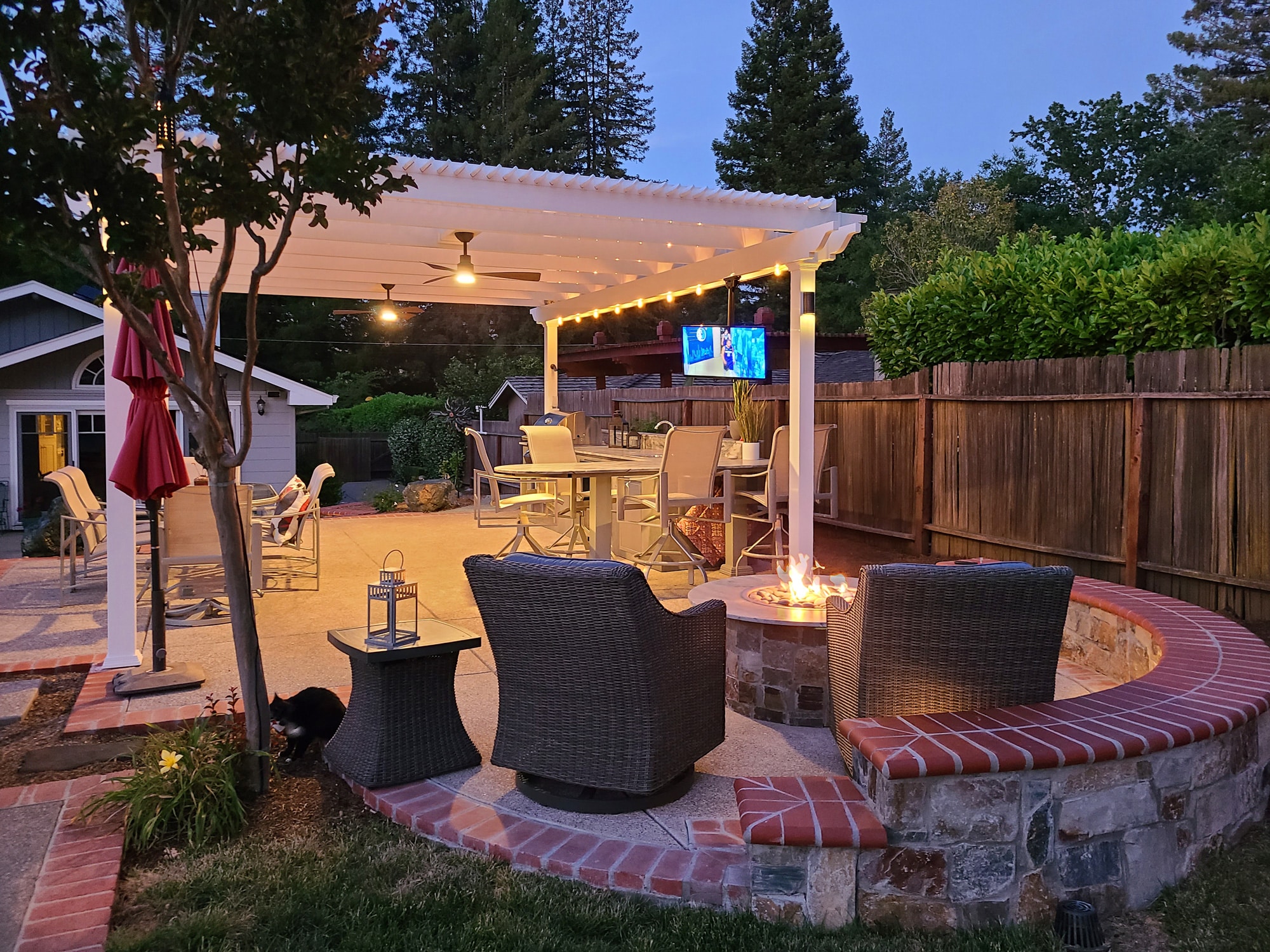 outdoor pergola with fans and outdoor tv at night lit up over patio