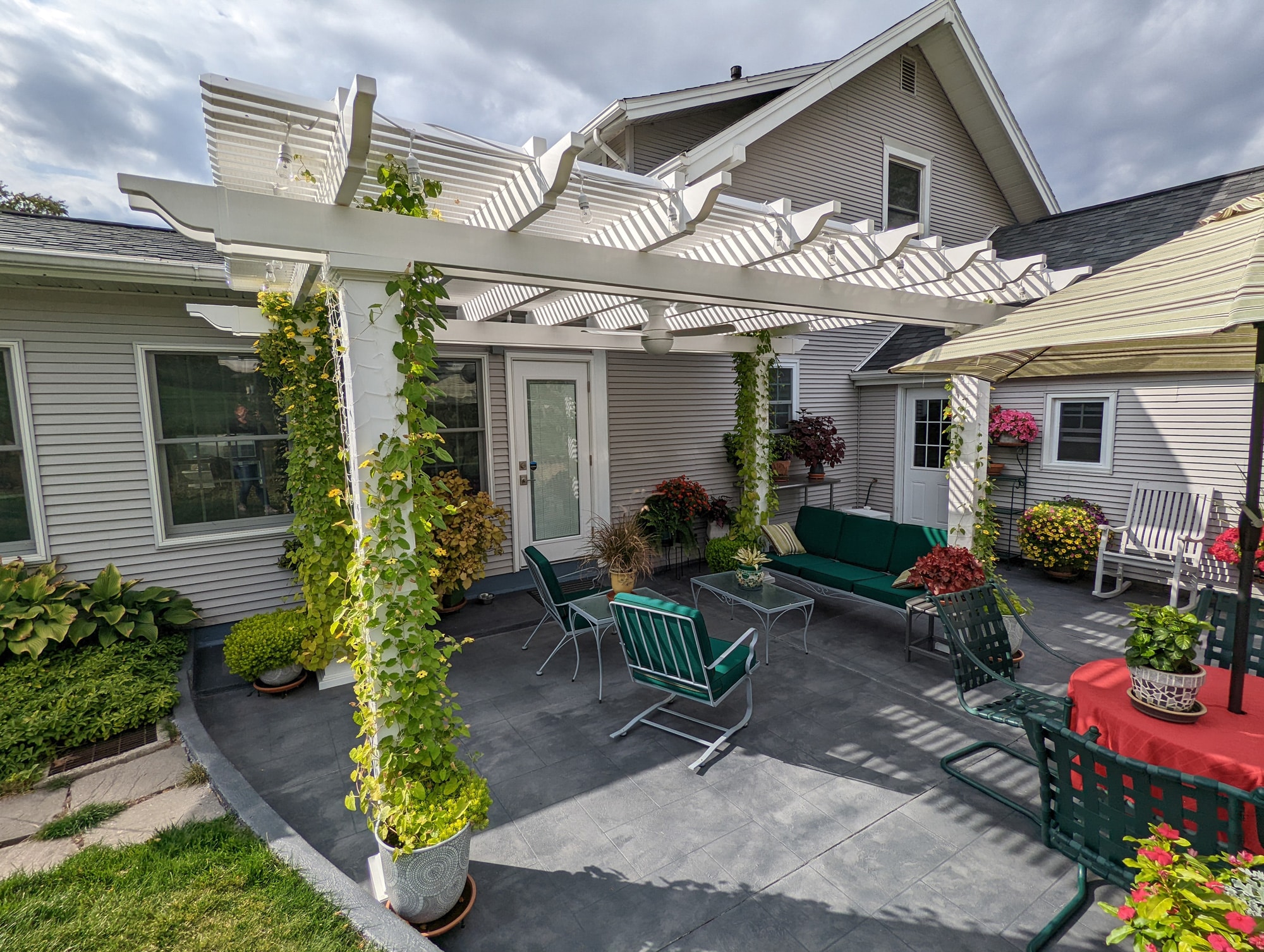 Freestanding vinyl pergola with vines growing up the posts